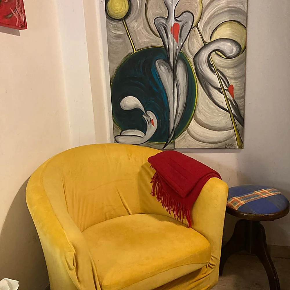 Poltrona gialla dello studio con plaid rosso e quadri alle pareti